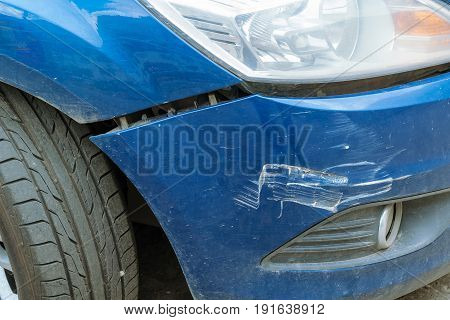 The car after the accident with a broken bumper. Between the fender and the bumper view of the crack. On the bumper are visible dings and scratches.