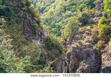 Thueyts, France, september 11, 2016: Man and woman climb a mountain along the river Ardeche