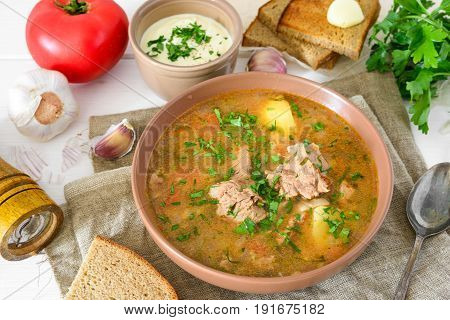 Kharcho is georgian soup with rice and meat served with bread and ingredients