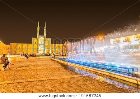 YAZD, IRAN - MAY 5, 2015: People socializing by the fountain and Amir Chakhmaq Complex in old city. Long exposition.