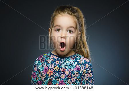 Closeup Portrait of little girl going surprise on gray background.