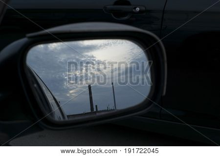 the reflection in the mirror of the pipes against the sky