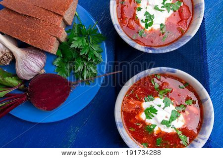 Ukrainian Traditional Borsch. Russian Vegetarian Red Soup  In Blue Bowl On Blue Wooden Background.