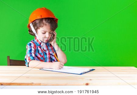 Young Cute Superintendent In A Helmet Speaks On The Phone, Sticking Out His Lip Pencil Writing In A