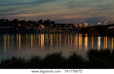 Irkutsk cityscape with Angara river after sunset with bridge and reflection of lights