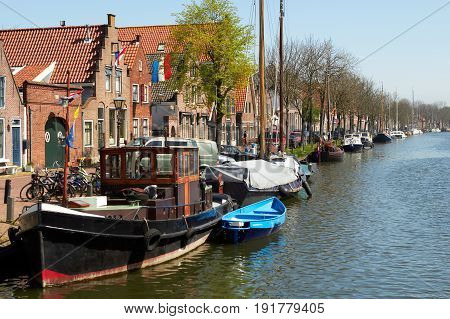 Traditional Dutch Botter Fishing Boats in the small Harbor of the Historic Fishing Village of Spakenburg-Bunschoten in the Netherlands. The village was at one time a harbor on the inland sea. Sprinf sunny day