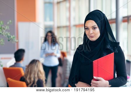 Arabian business woman with hijab holding a folder.