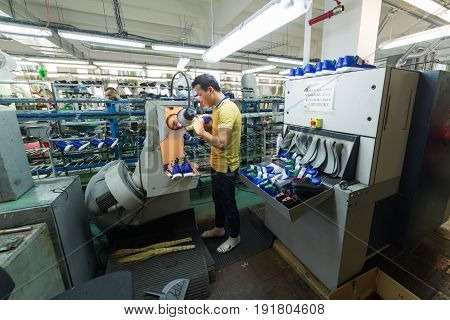 MOSCOW, RUSSIA - FEBRUARY 21, 2017: Moscow shoe factory JSC RALF RINGER. Worker working in a shoe factory, finishing at a grinder machine