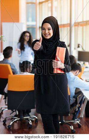 Arabian business woman with hijab holding a folder.