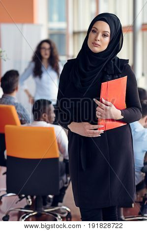 Arabian business woman with hijab holding a folder.