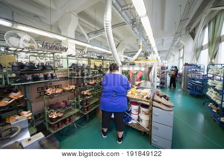 MOSCOW - FEB 21, 2017: Women glue shoes in workshop in Ralf Ringer factory. company production is 1,5 million pairs per year