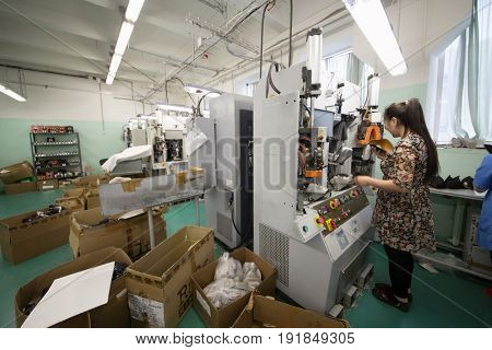 MOSCOW - FEB 21, 2017: Woman works on machine in workshop in Ralf Ringer factory. Company production is 1,5 million pairs per year