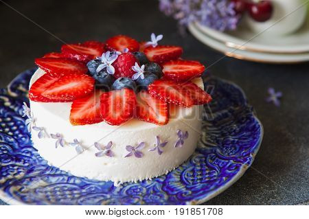 Vanilla mousse cake with fresh berries and edible flowers