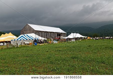 SIGLERVILLE PENNSYLVANIA - June 17 2017: A cloudy day at an annual Amish benefit auction in Mifflin County. Sale items include quilts tools food farm machinery and antiques.