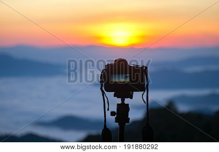 Closeup of a camera on a tripod outdoors. Background Landscape out of focus