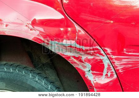 Red scratched car. Damaged car paint on parking.