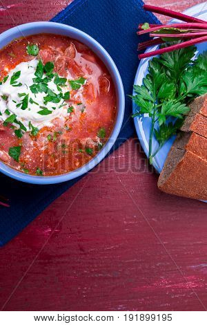 Ukrainian Traditional Borsch. Russian Vegetarian Red Soup  In Blue Bowl On Red Wooden Background.  B