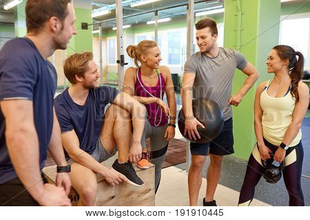 fitness, sport, exercising and healthy lifestyle concept - group of happy people with skipping rope, medicine ball and kettlebell in gym