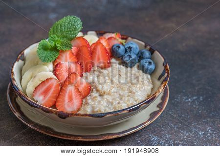 Bowl of delicious irish steel cut oats with fresh fruit, honey