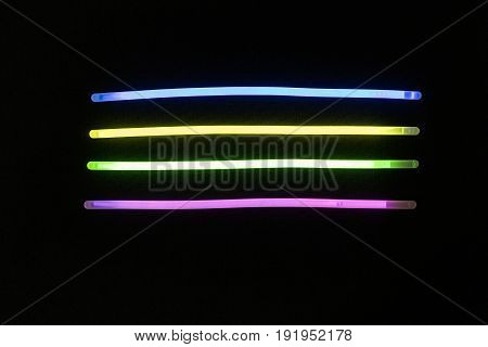 Glow sticks neon light fluorescent on back background. variation of different colored chem lights
