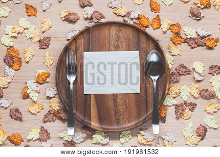 Paper on set of dish with maple leaves on wood background
