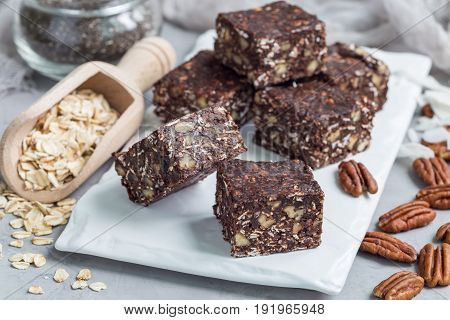 Paleo chocolate energy bars with rolled oats pecan nuts dates chia seeds and coconut flakes horizontal
