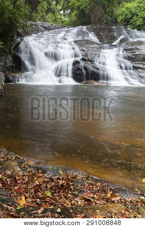 River Flowing Over Wet Rocks And The Debengeni Waterfall