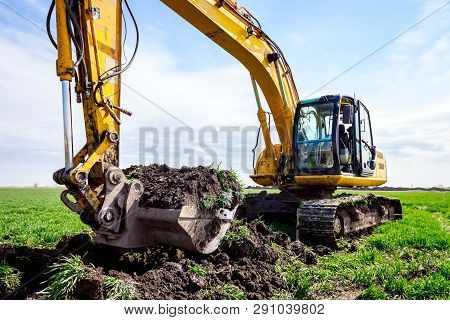 Big Excavator Is Excavating Soil At Construction Site, Project In Progress.