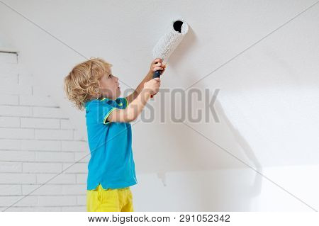 Kids Painting Attic Wall. Home Improvement And Renovation. Child Applying White Paint On Brick Walls