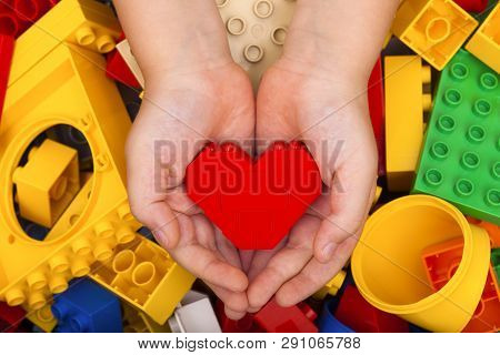 Tambov, Russian Federation - September 07, 2015 Lego Red Heart In Child Palms With Lego Duplo Blocks