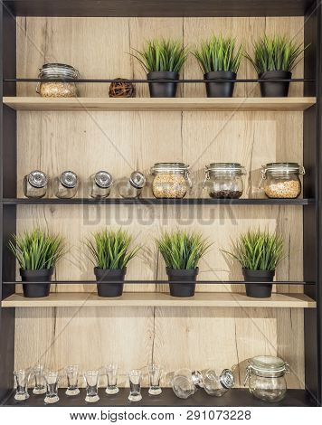 Wooden Helf With Kitchenware. Glass Jars With Spices Pot Plant Glasses On The Wooden Rack Kitchen Ba