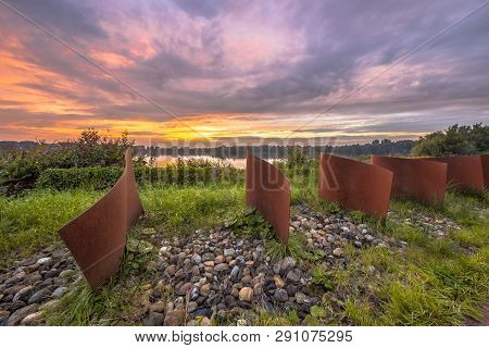 Metal Waved Objects In Landscape With Lake And Sunset At Piccardthofplas Groningen City, Netherlands