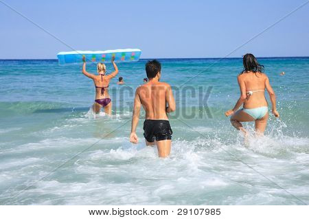 Gruppo di tre amici - uomo e donna - sulla spiaggia avendo un sacco di divertimento in vacanza in Grecia
