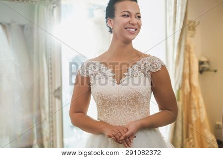 Beautifu bride choosing wedding dress in a wedding salon
