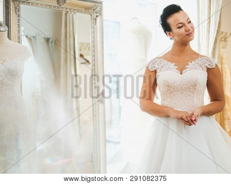 Beautifu bride choosing wedding dress in a wedding salon
