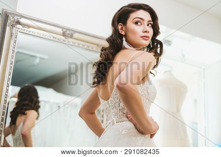Beautifu bride choosing wedding dress in a wedding salon