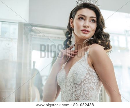 Beautifu bride choosing wedding dress in a wedding salon