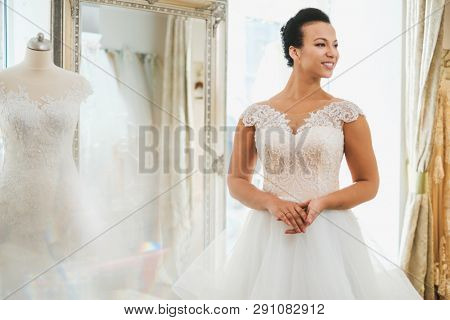 Beautifu bride choosing wedding dress in a wedding salon