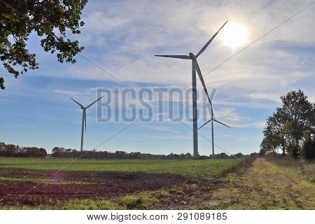 View On Alternative Energy Windmills In A Windpark In Northern Germany In Front Of A Blue Sky