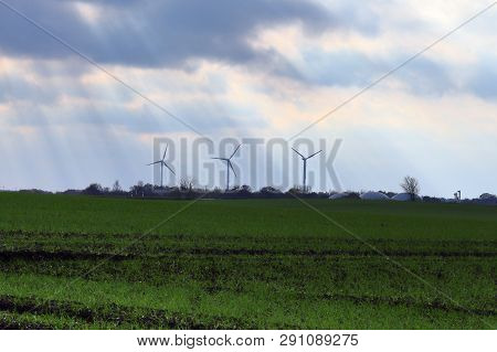 View On Alternative Energy Windmills In A Windpark In Northern Germany In Front Of A Blue Sky