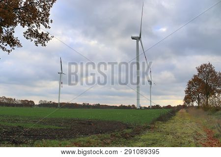 View On Alternative Energy Windmills In A Windpark In Northern Germany In Front Of A Blue Sky