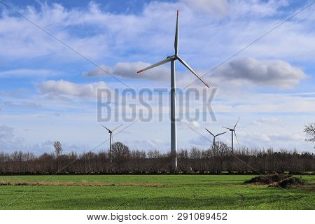 View On Alternative Energy Windmills In A Windpark In Northern Germany In Front Of A Blue Sky