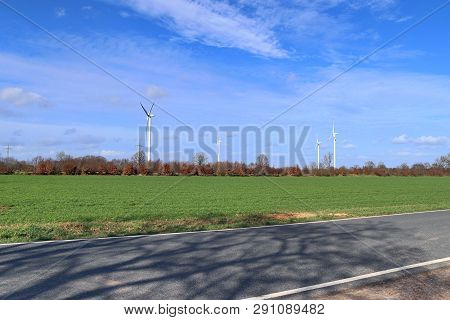 View On Alternative Energy Windmills In A Windpark In Northern Germany In Front Of A Blue Sky