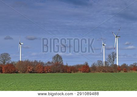 View On Alternative Energy Windmills In A Windpark In Northern Germany In Front Of A Blue Sky