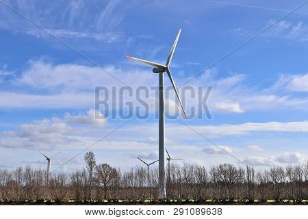 View On Alternative Energy Windmills In A Windpark In Northern Germany In Front Of A Blue Sky