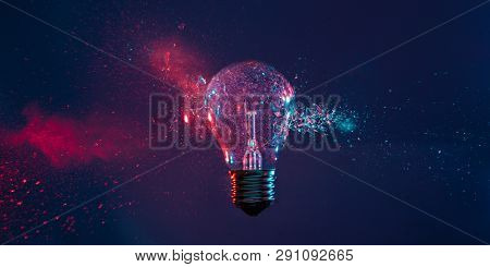 High speed studio photography, moment of the impact of a bullet on a classic electric bulb. Detail of glass explosion, blue and purple lighting. Concept of obsolete energy.