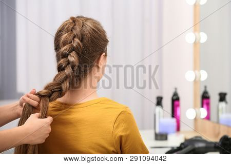 Professional Coiffeuse Braiding Client's Hair In Salon