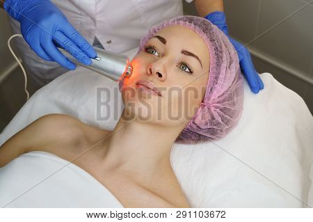 Hardware Cosmetology. Ultrasound Chromotherapy. Beautician Carries Out Procedure For Tightening Skin