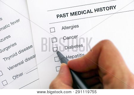 Past Medical History Questionary. Person Hand With Pen Ready To Ticked Diabetes. Close-up.