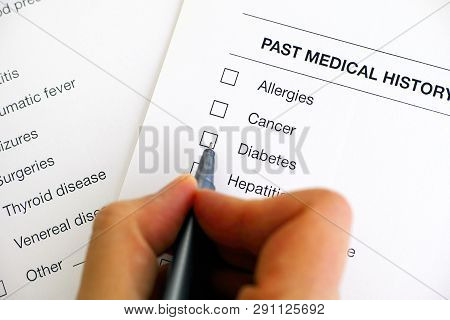 Past Medical History Questionary. Woman Hand With Pen Ready To Ticked Diabetes. Close-up.